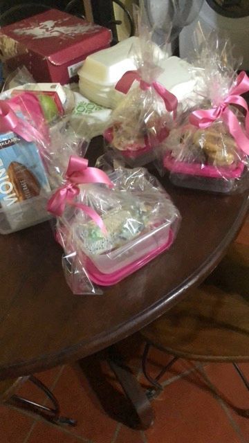 A table with a bunch of food wrapped in plastic and a box that says ' mom ' on it