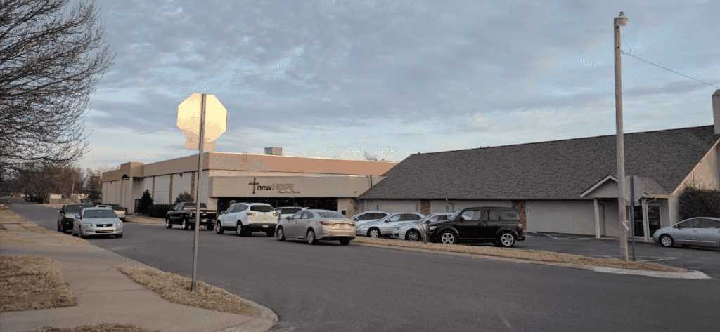 A parking lot with cars parked in front of a building.