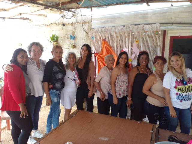 A group of women are posing for a picture and one woman is wearing a shirt that says mama