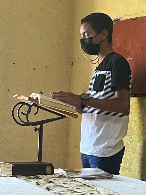 A man wearing a mask is reading a book