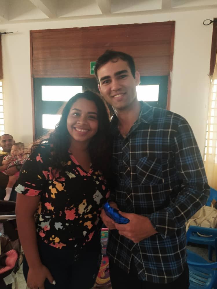 A man and a woman are posing for a picture in a room.