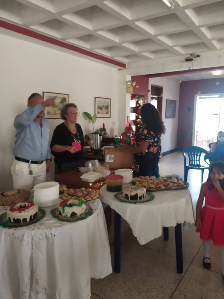 A group of people standing around a table with cakes on it