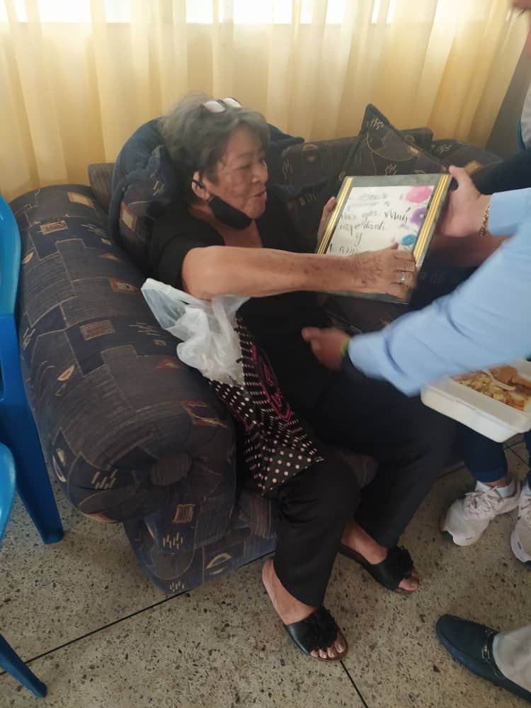 A woman is laying on a couch holding a picture frame