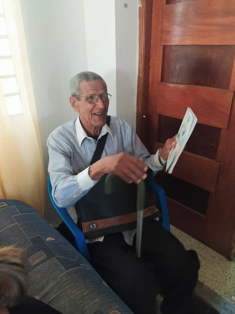 A man is sitting in a chair holding a piece of paper