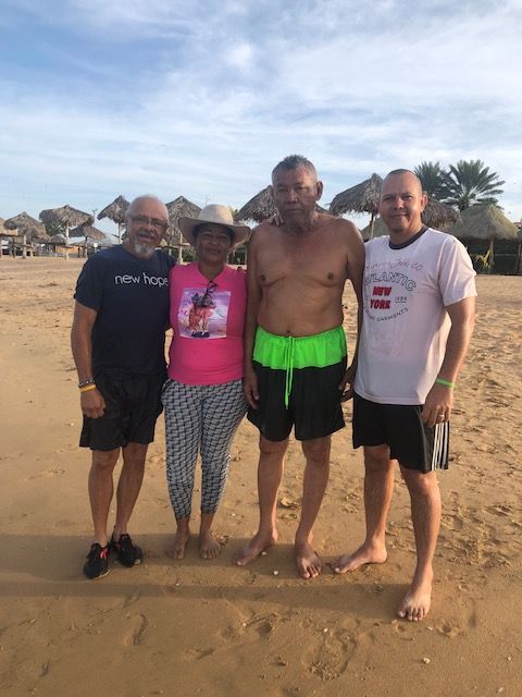 A group of people posing for a picture on the beach