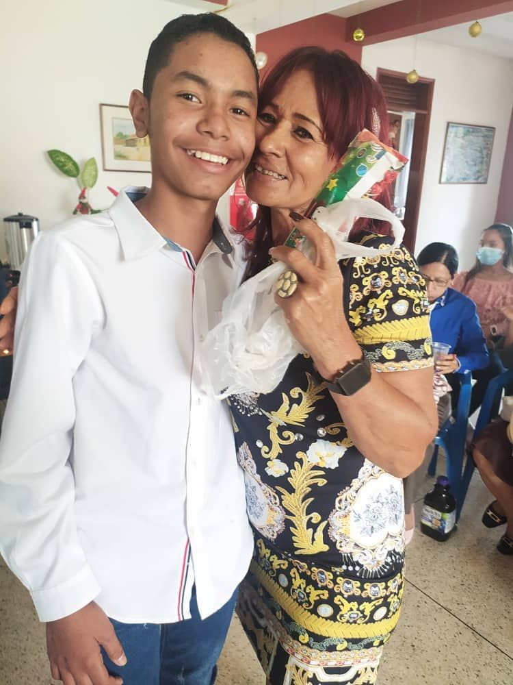 A woman and a boy are posing for a picture in a room.