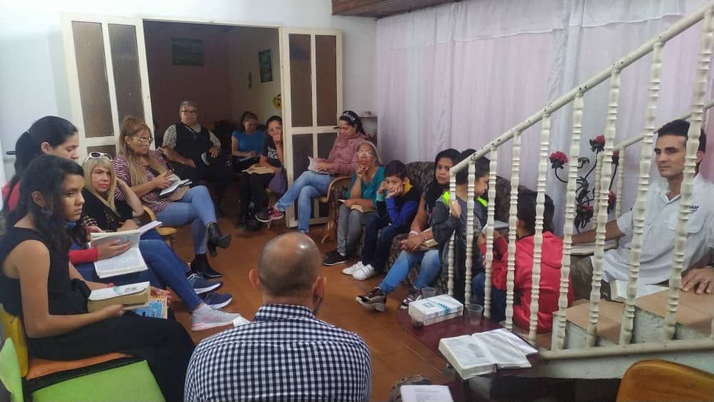 A group of people are sitting in a circle in a room.