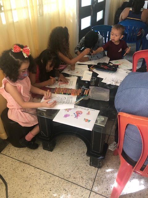 A group of children are sitting around a table drawing