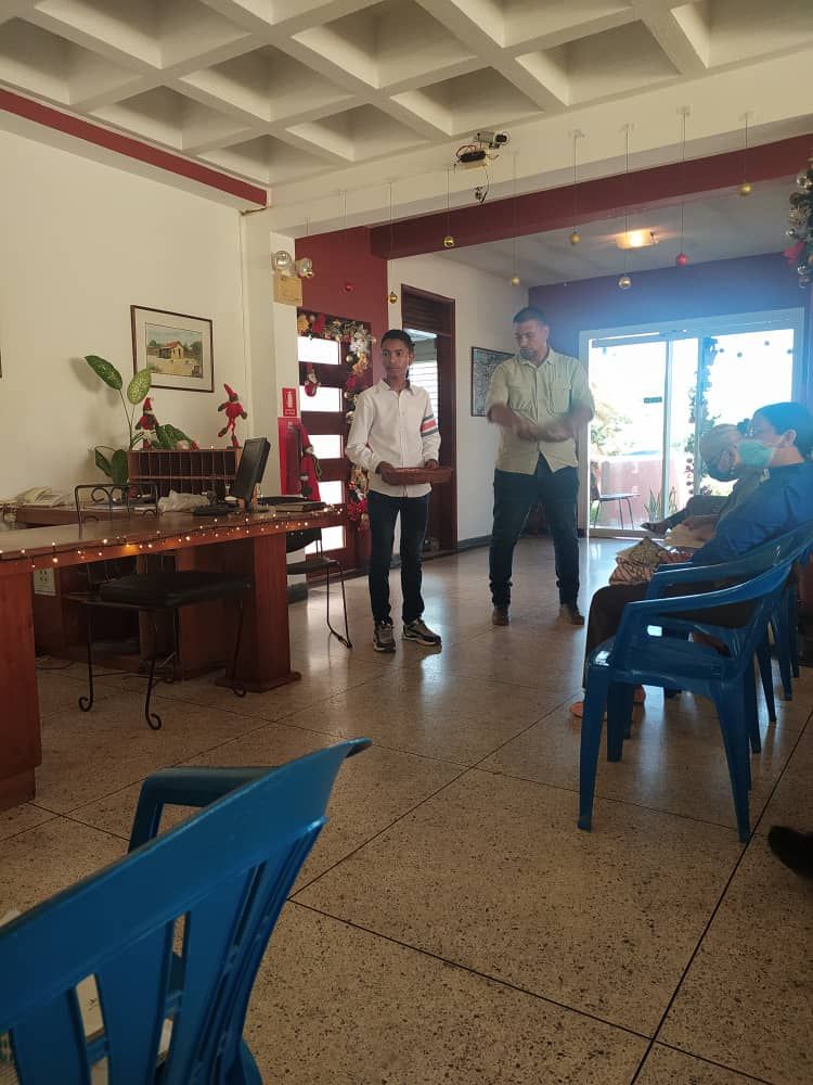A group of people are standing in a room with blue chairs.