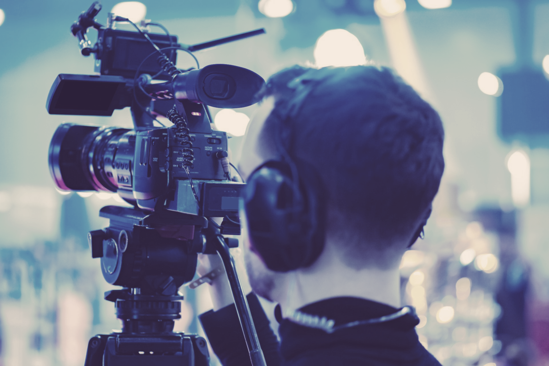 A man wearing headphones is recording a video with a video camera.