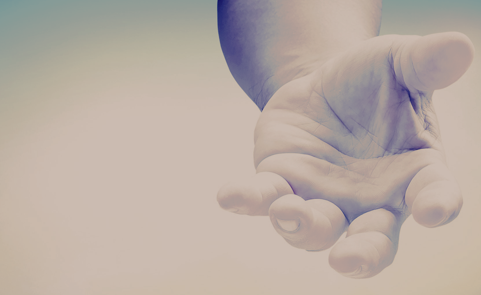 A close up of a person 's hand reaching out towards the sky.