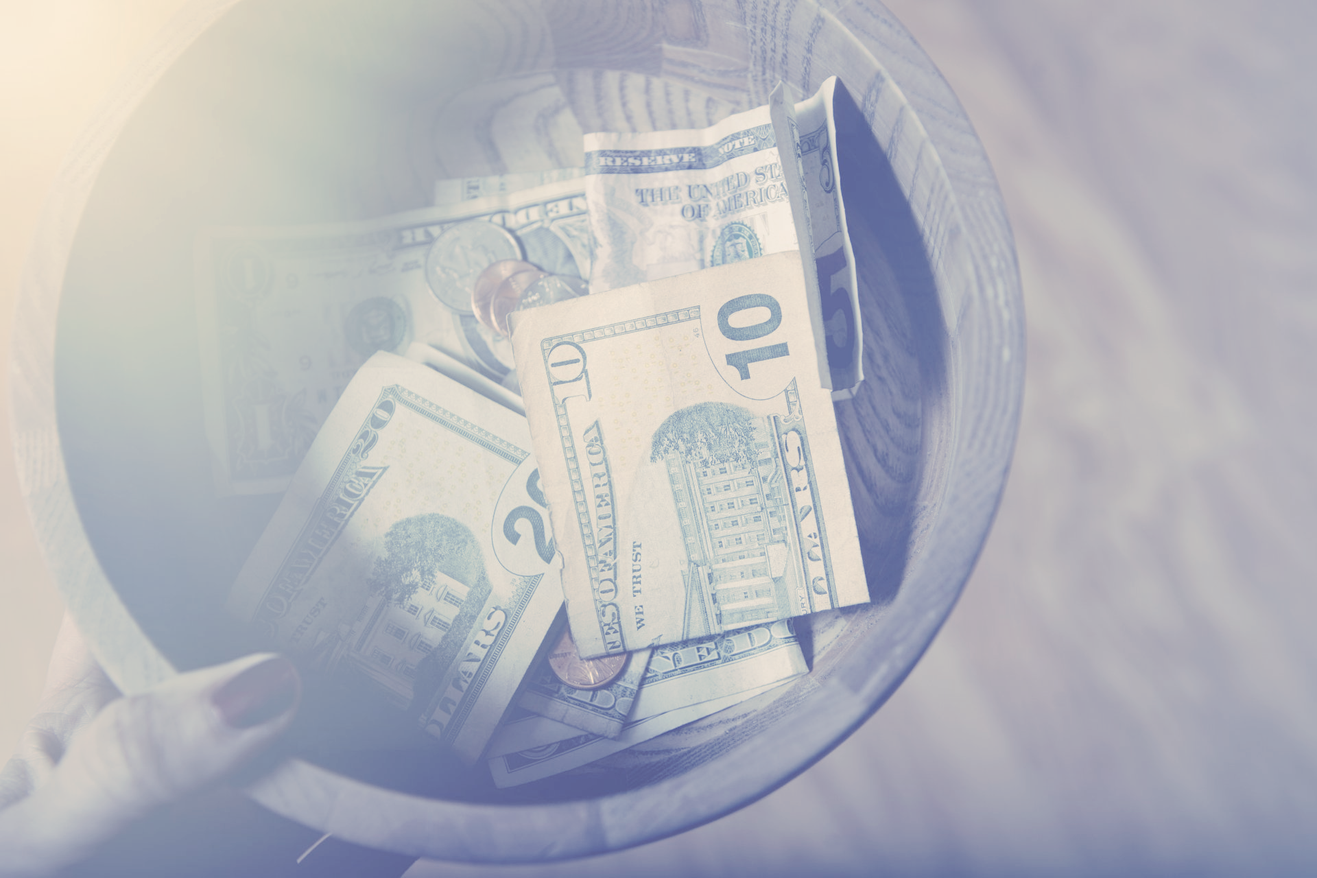 A glass jar filled with money on a table.