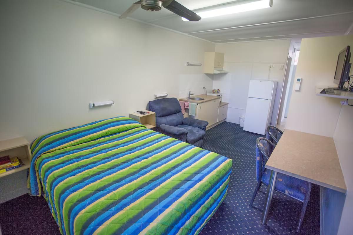 Small Motel Room With Bed, Kitchenette, Chair, Desk, and Tv — Fourth Avenue Motor Inn in Parkside, QLD
