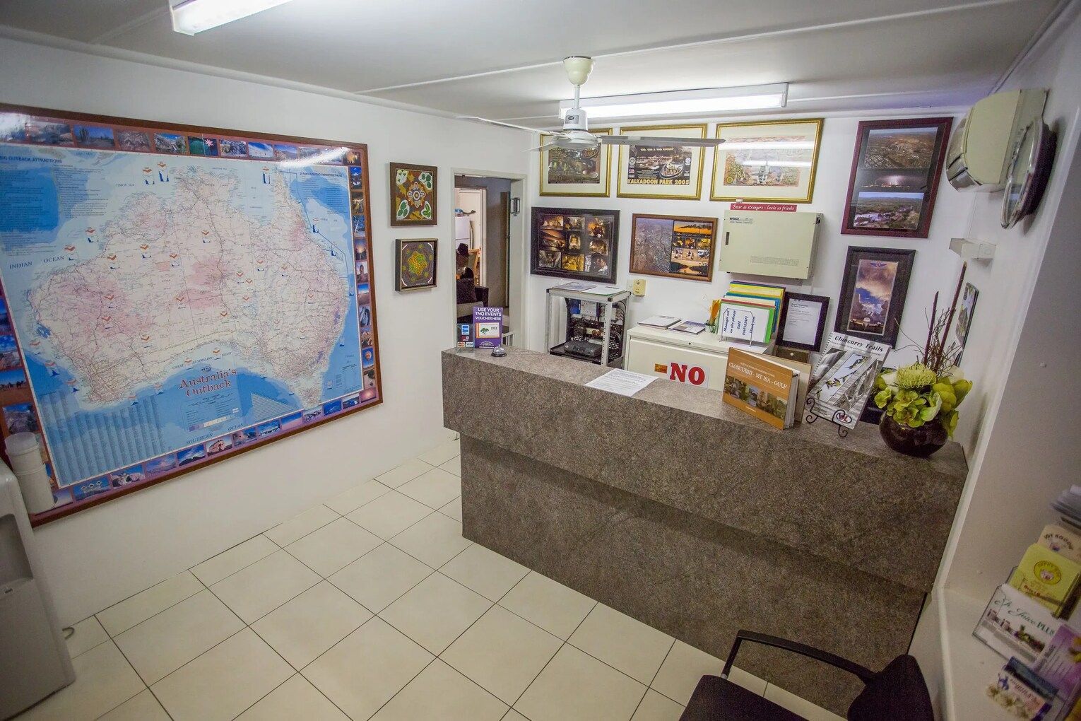 Motel With Parked Cars in Front of Rooms, Gravel Lot, Blue and Green Color Scheme — Fourth Avenue Motor Inn in Parkside, QLD