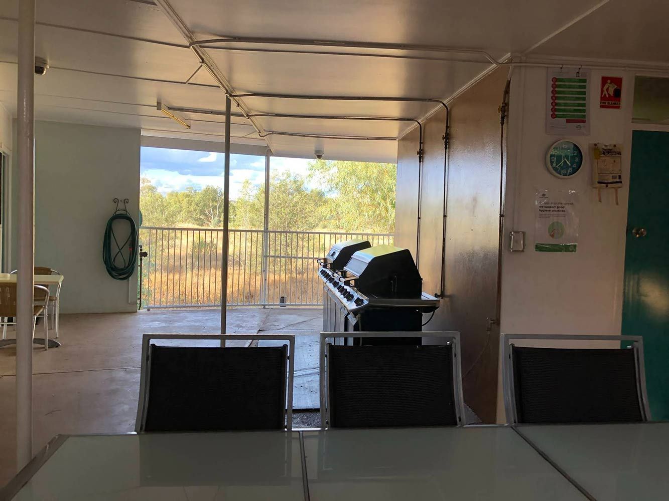 View From a Table Overlooking an Outdoor Grill and Railing, With Natural Landscape — Fourth Avenue Motor Inn in Parkside, QLD
