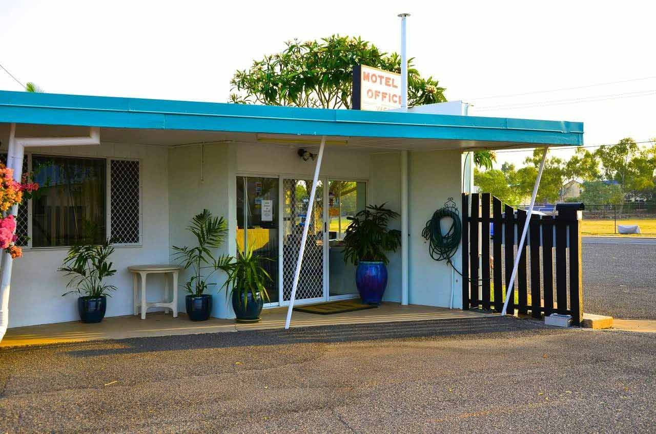 Hotel Office With Teal Awning, Potted Plants, and a Black Fence — Fourth Avenue Motor Inn in Parkside, QLD
