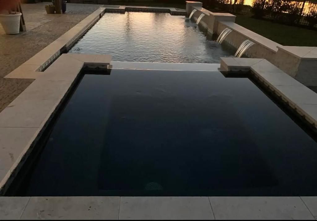 A large swimming pool with a waterfall in the middle