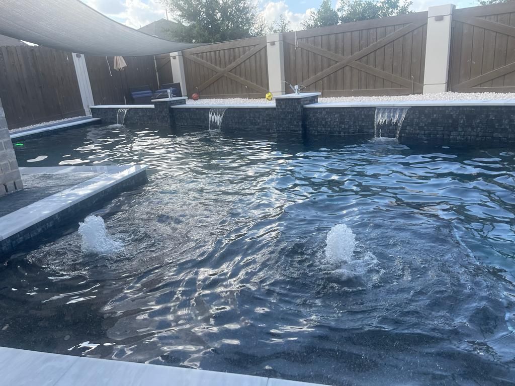 A large swimming pool with a fountain in the middle of it.