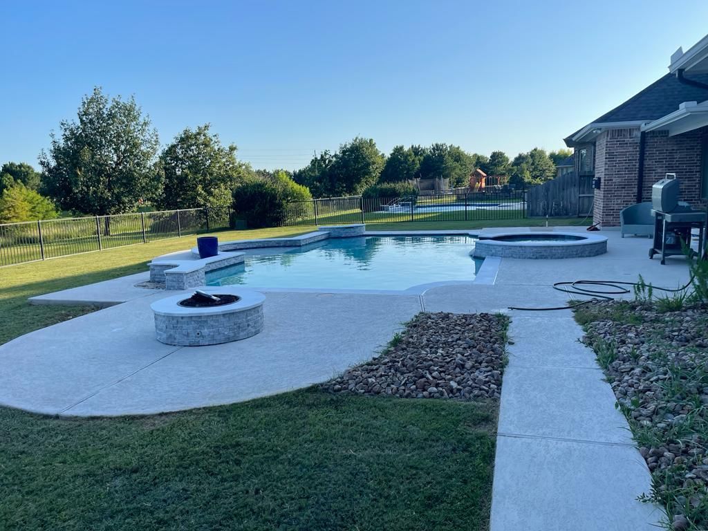 A large swimming pool with a fire pit in the backyard of a house.