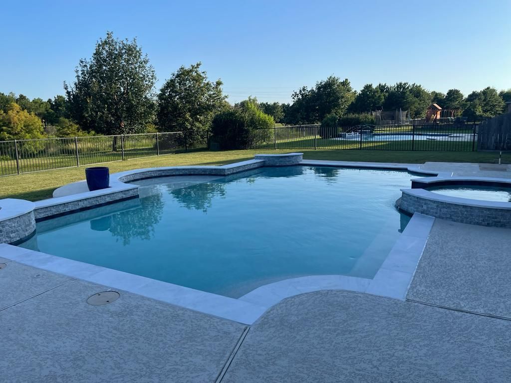 A large swimming pool in a backyard with trees in the background