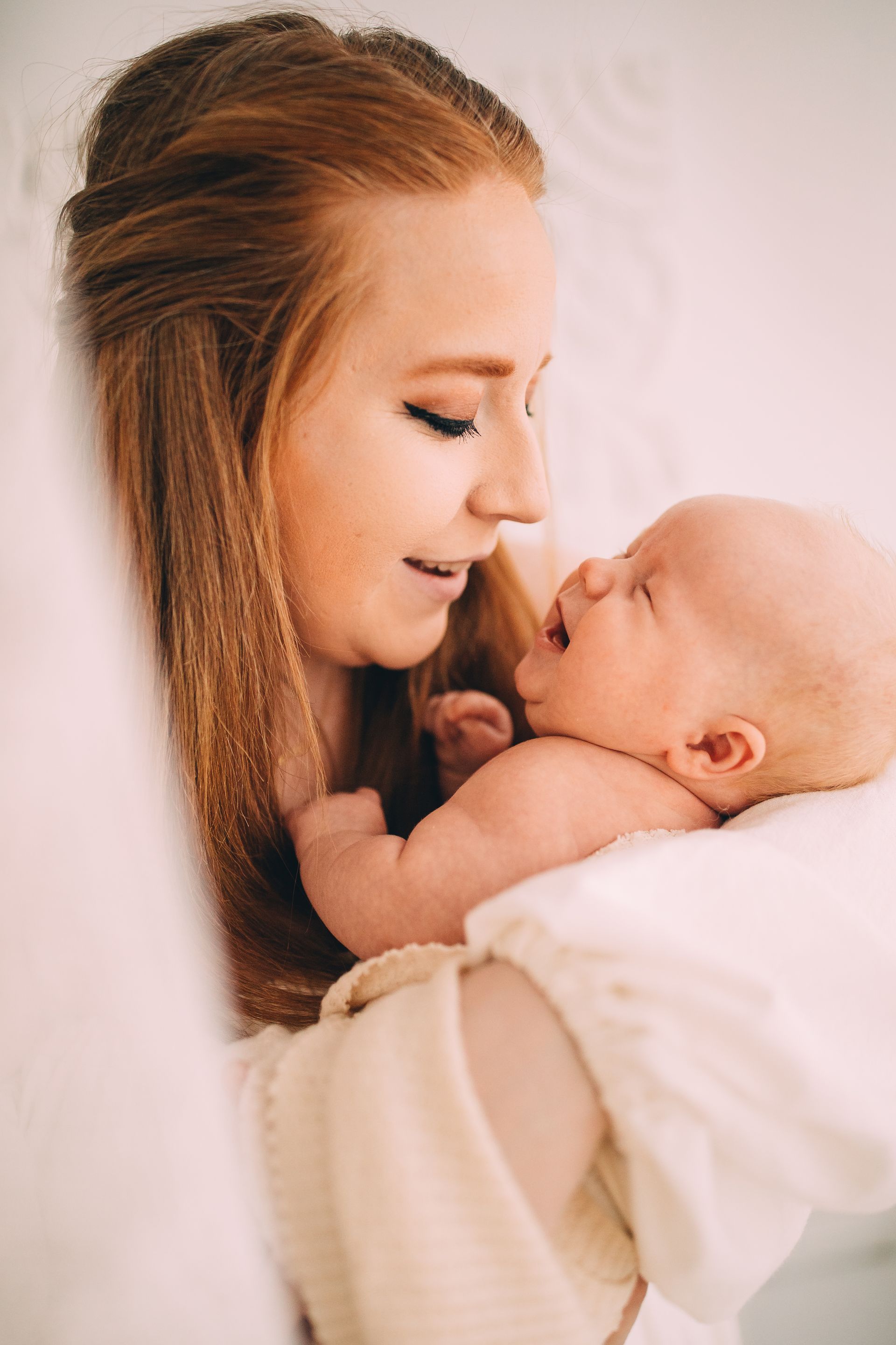 Woman holding and looking at crying infant.