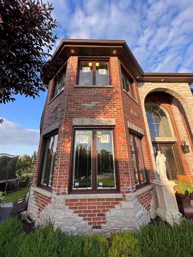 A large brick house with a lot of windows and a statue in front of it.