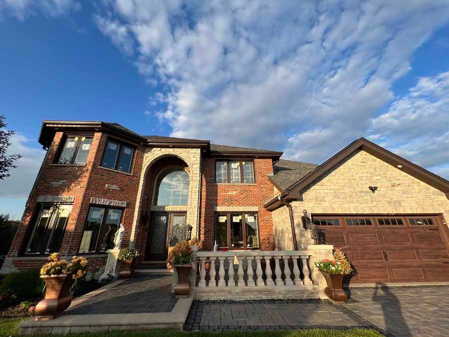 A large brick house with a large garage and a balcony.