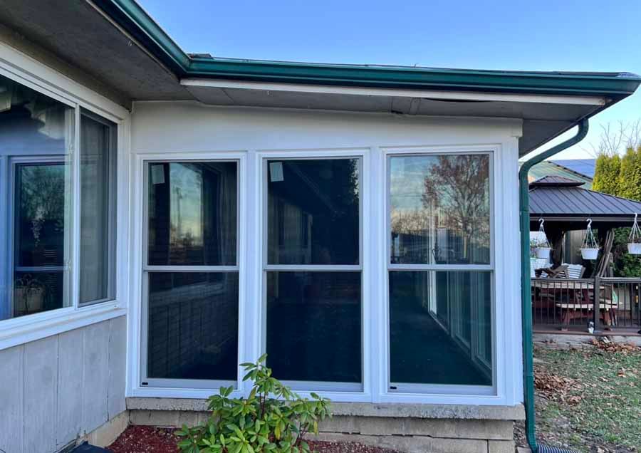 A house with a screened in porch and a lot of windows.