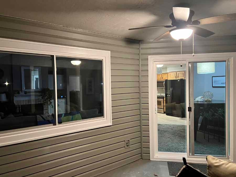 A living room with a ceiling fan and a sliding glass door.