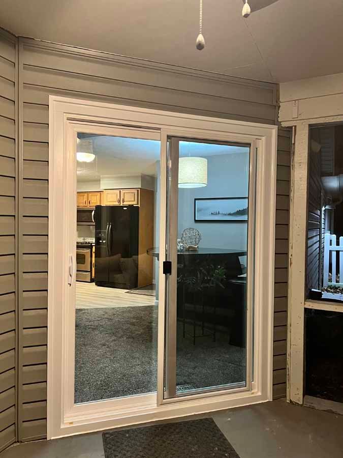 A sliding glass door is open to a living room in a house.