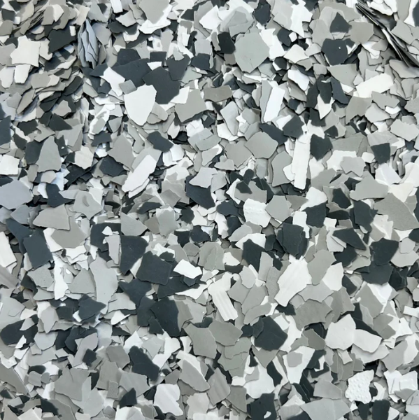 A close up of a pile of gray , white and black flakes.
