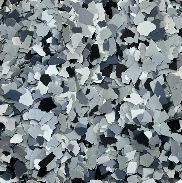 A close up of a pile of gray , white and black flakes