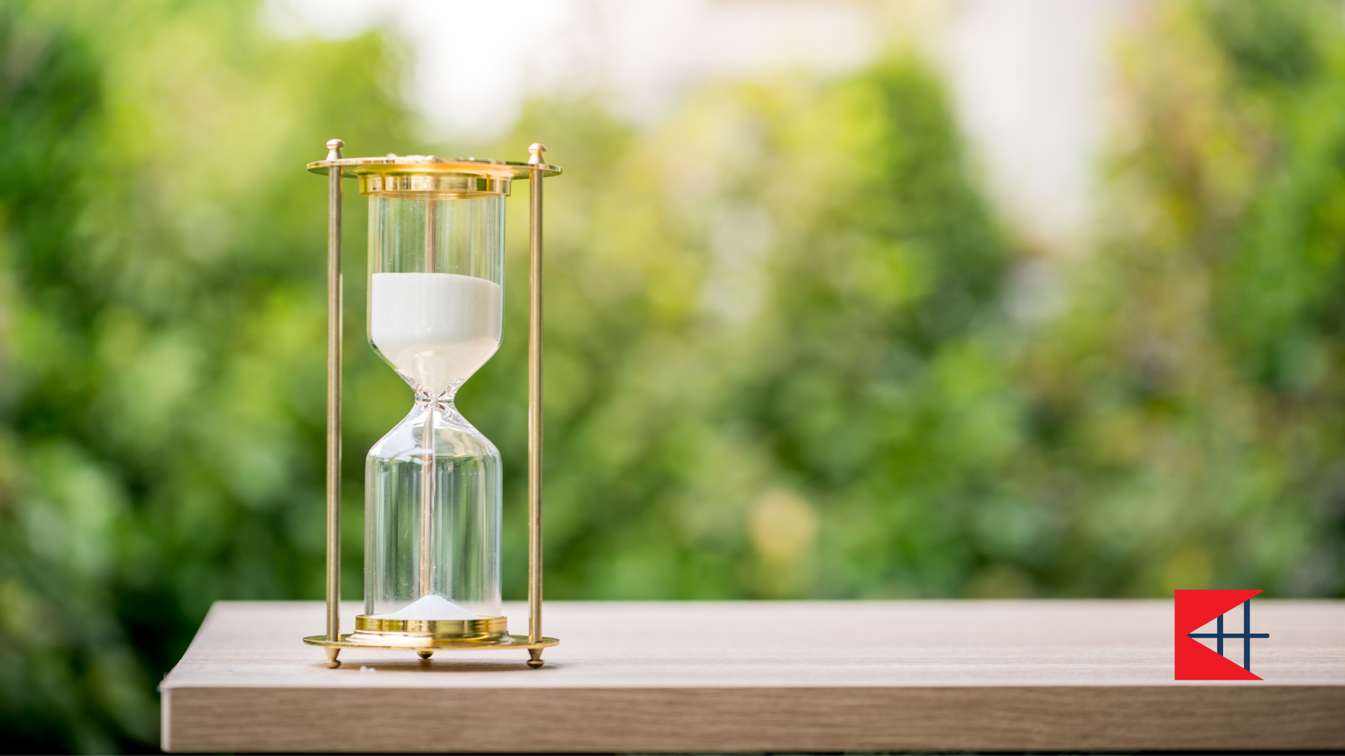 A hourglass is sitting on a wooden table.