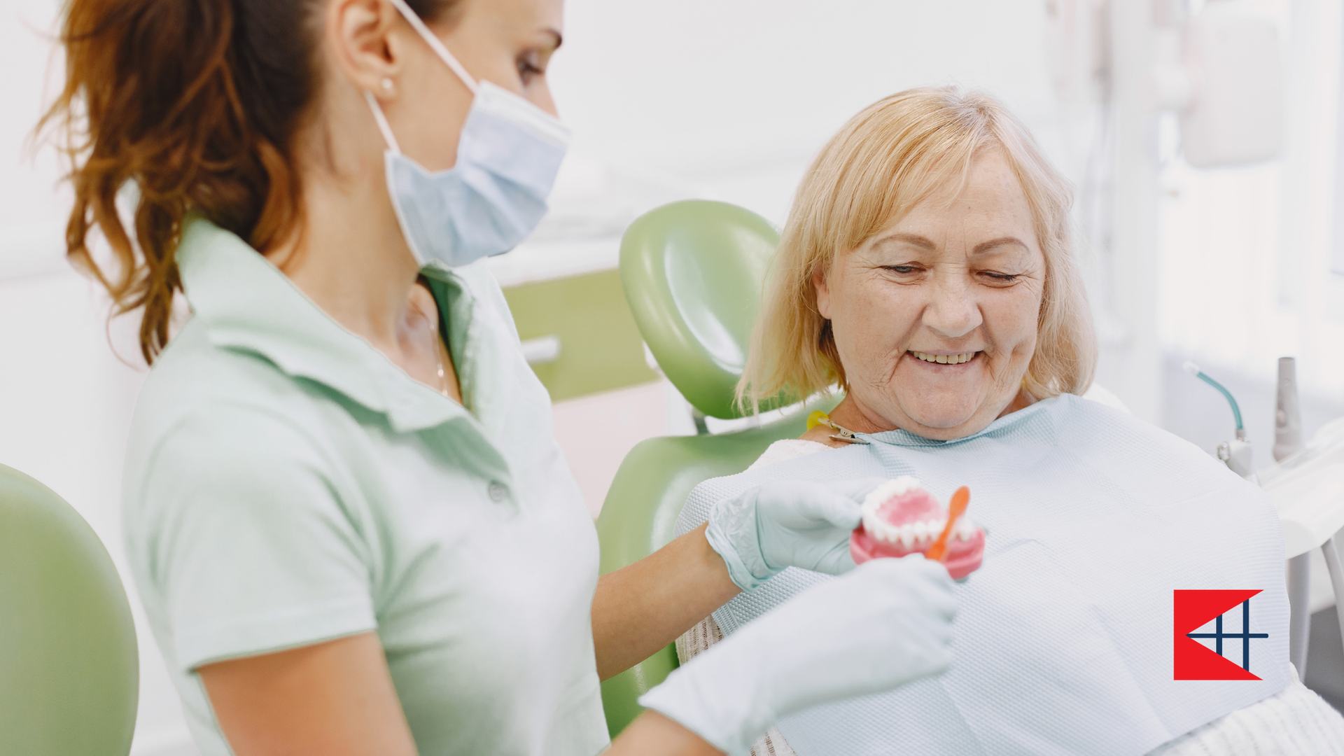 A woman is sitting in a dental chair while a dentist examines her teeth.