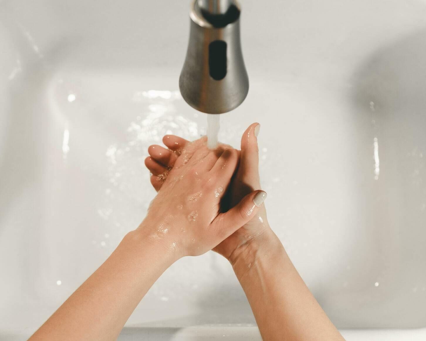 A Person Is Washing Their Hands In A Sink With Soap — Springs Cleaning Supplies In Ciccone, NT