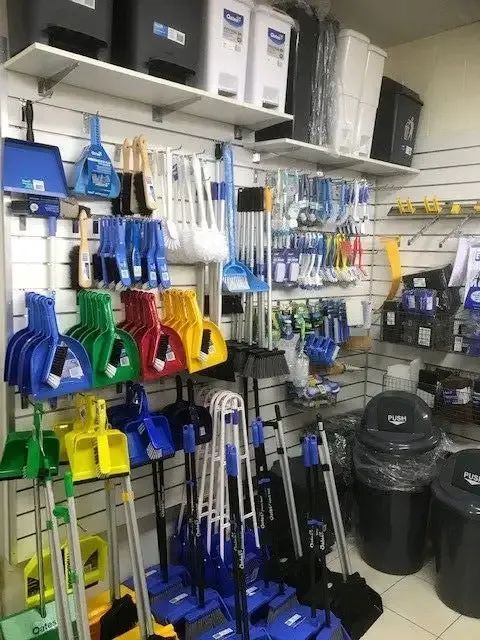 A Woman Is Standing In A Living Room Holding A Mop — Springs Cleaning Supplies In Ciccone, NT