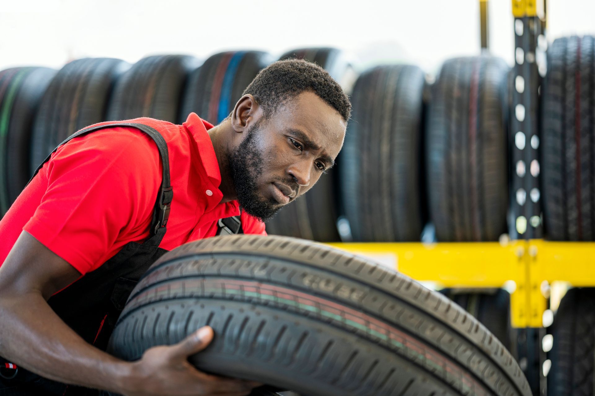 A man is examining a tire.