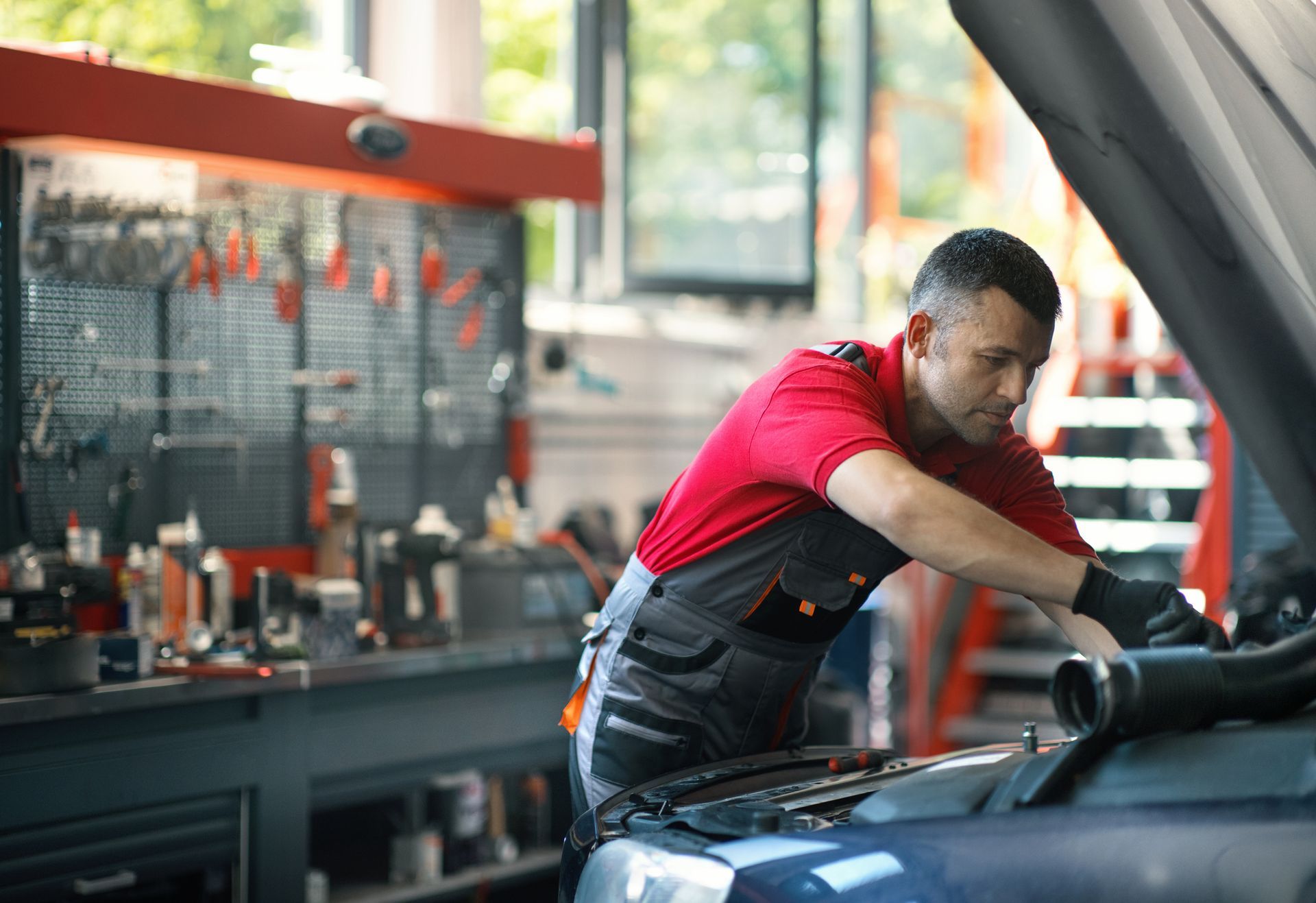 Mechanic working on an engine at a car repair shop. Mechanic working on an engine at a car repair shop.