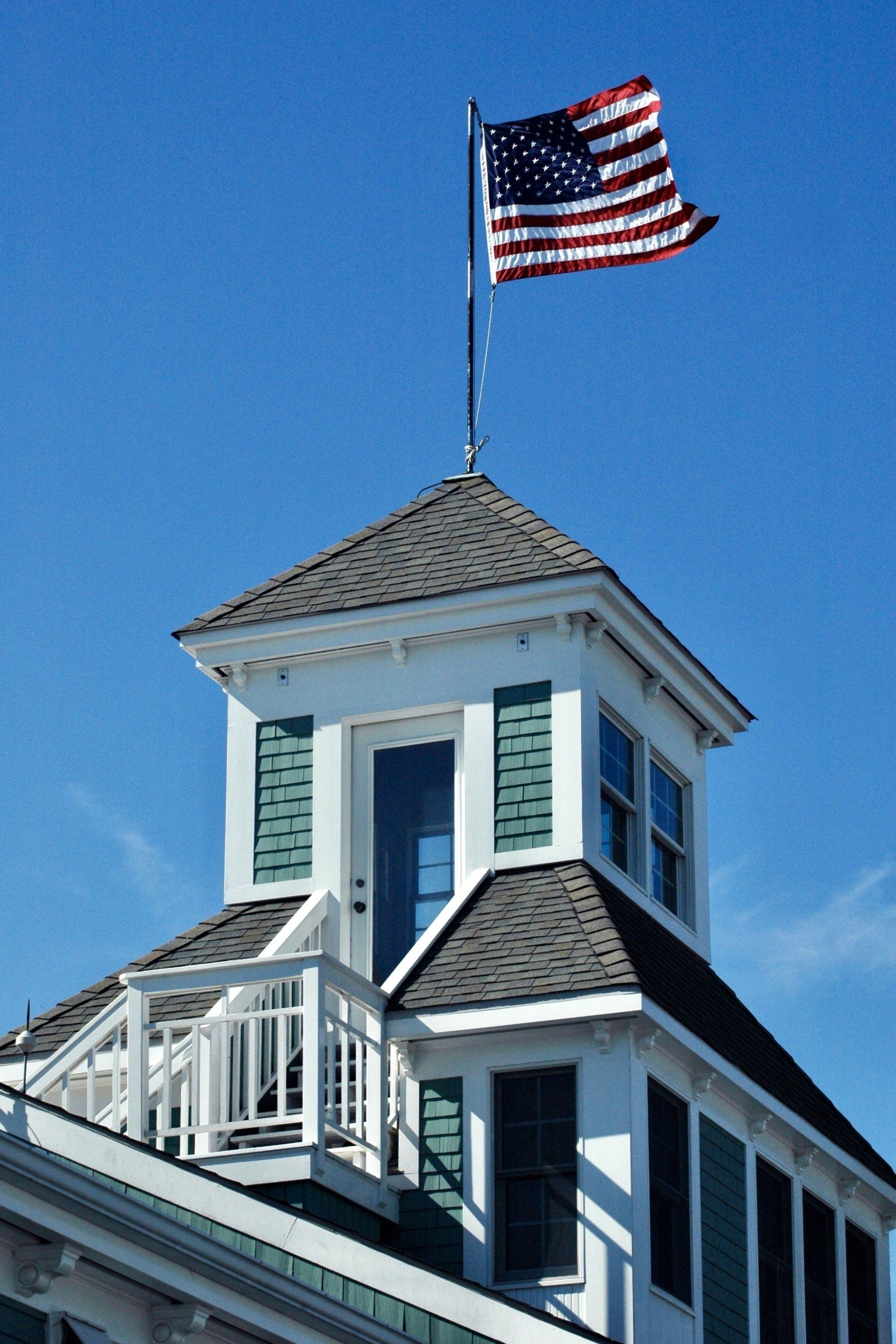 A tower with stairs and windows and an American flag on top