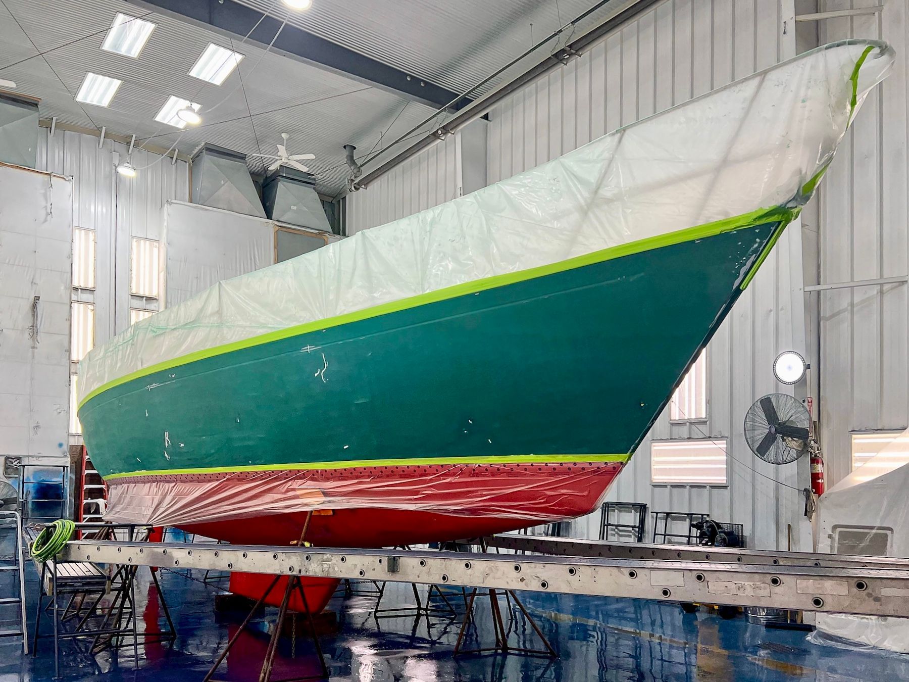 Boat in paint shop with green hull