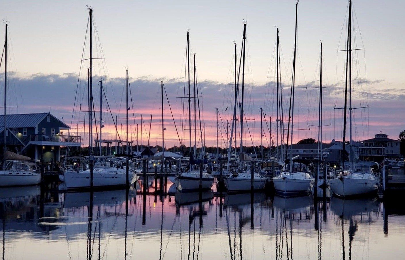 Sailboats and dock during a sunset