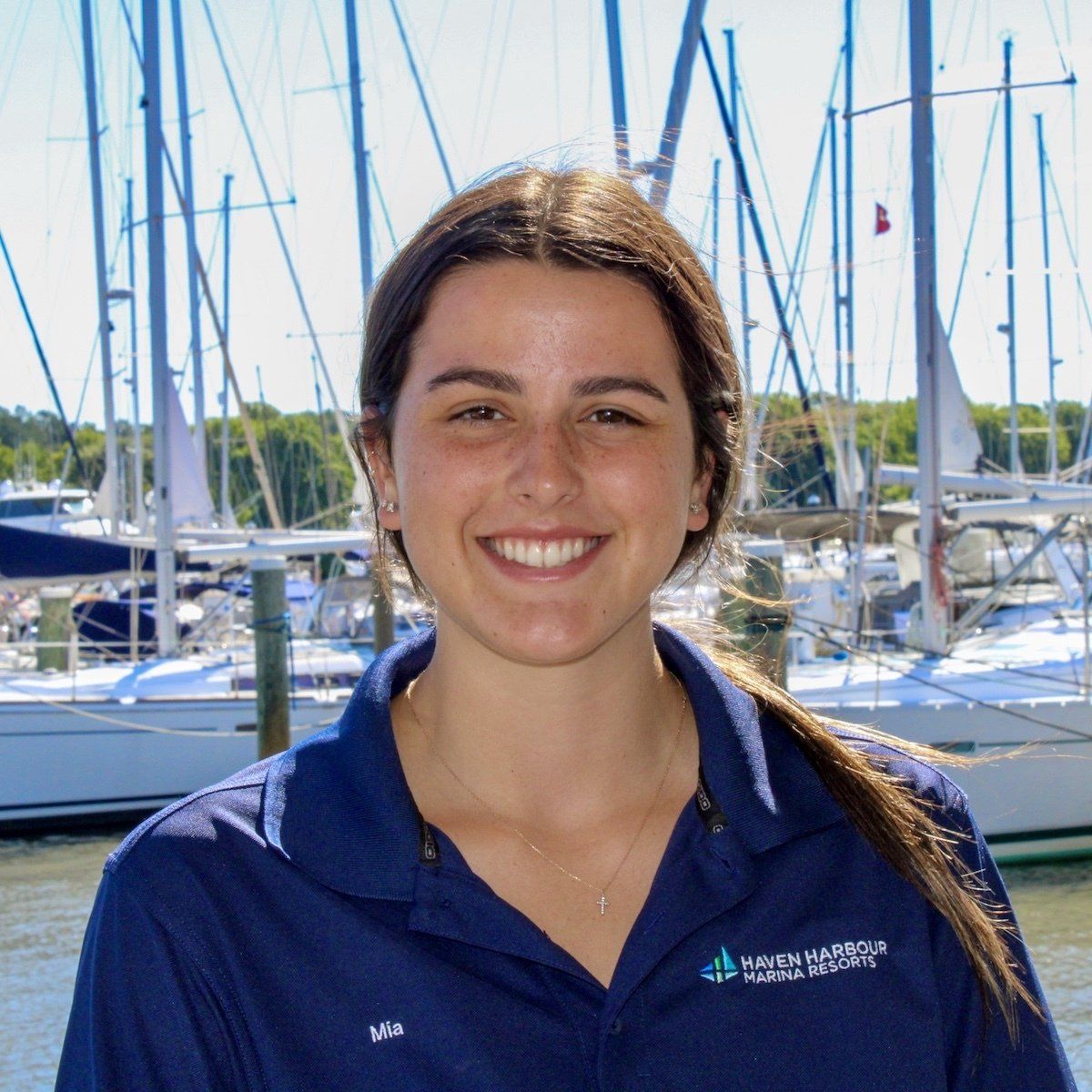 Female employee pictured outside in front of sailboats