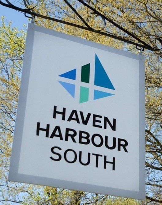 Hanging outdoor sign that reads Haven Harbour South