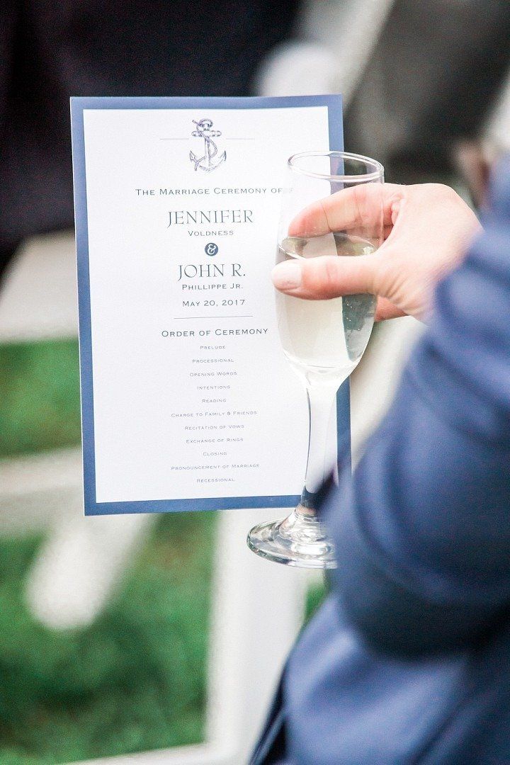 Man holding a wedding announcement with a glass of wine