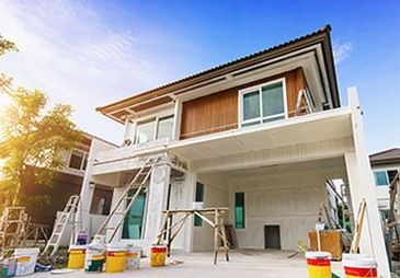A house is being painted with buckets of paint and a ladder.