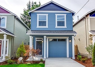 A blue house with white trim and a blue garage door