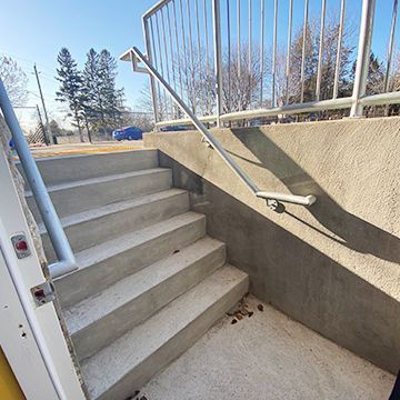A set of stairs leading up to a building with a railing.