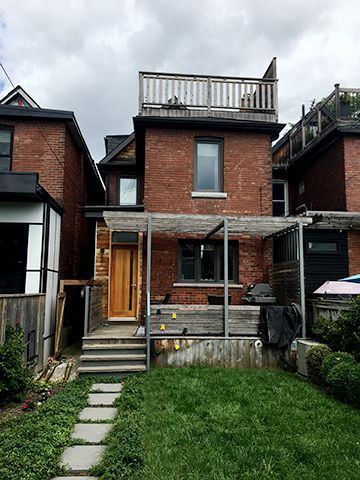 A brick house with a large lawn in front of it.