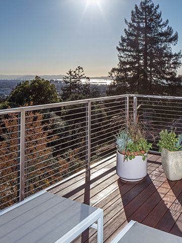 A balcony with a view of the ocean and trees