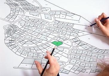 A person is drawing a map of a city with a pencil.